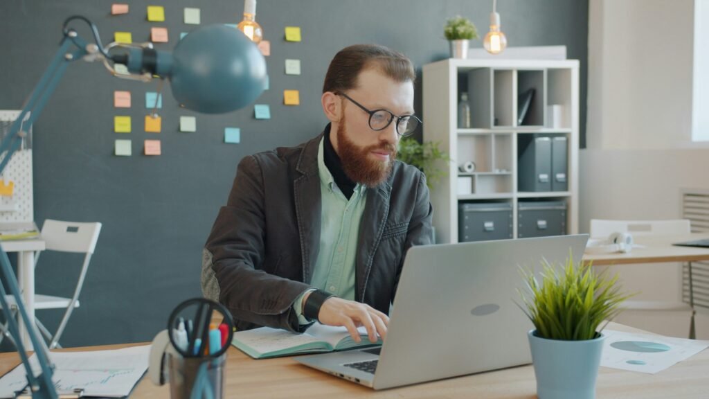 Business professional working on a laptop in a modern office, illustrating AI tools for business productivity